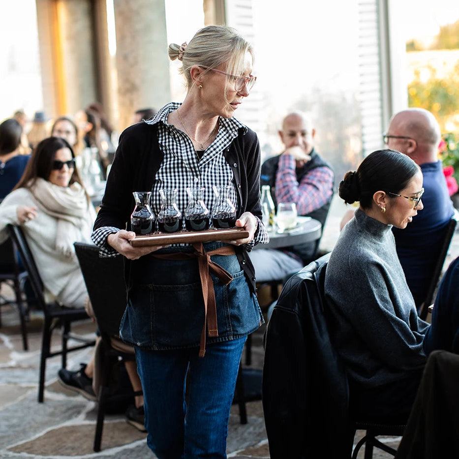 Waitress carrying a tray with drinks in an outdoor restaurant setting